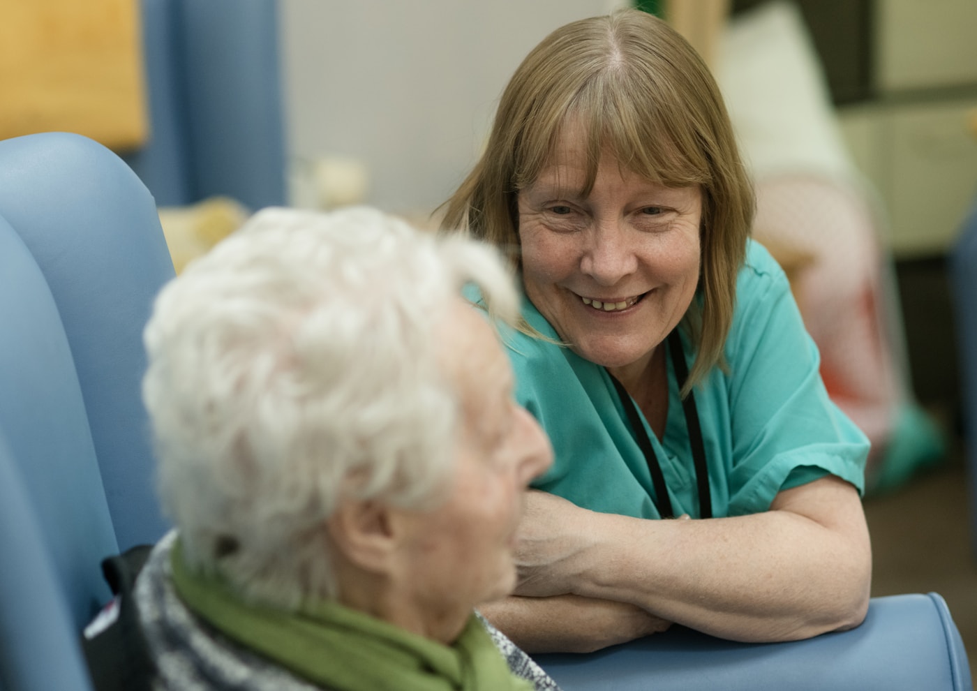 Caregiver talking warmly with an older adult in a home-like setting
